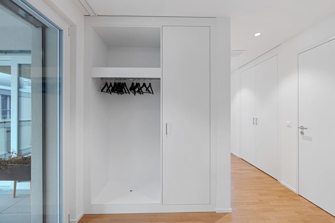 hallway wardrobe with sliding door, hanging rail, and black hangers