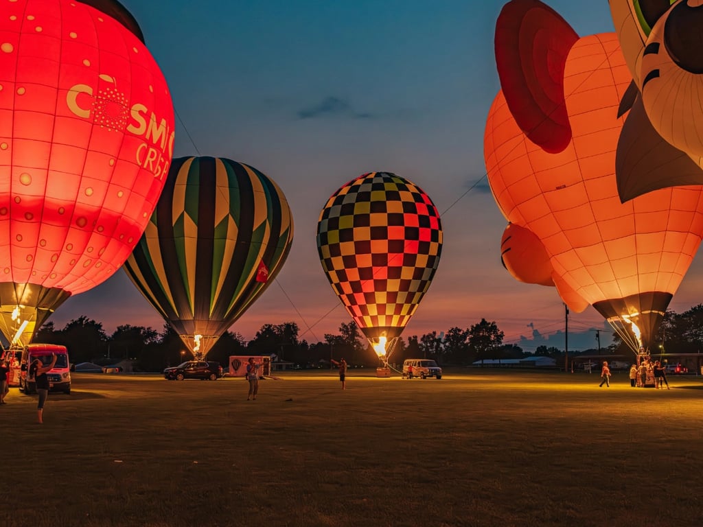 Hot air balloons glowing brightly during the evening illumination event