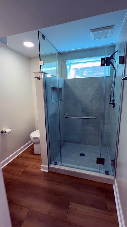 New glass-enclosed shower in a finished basement bathroom