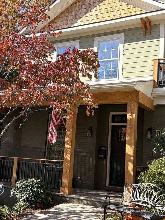 A freshly painted yellow home exterior with a covered front porch and wood columns