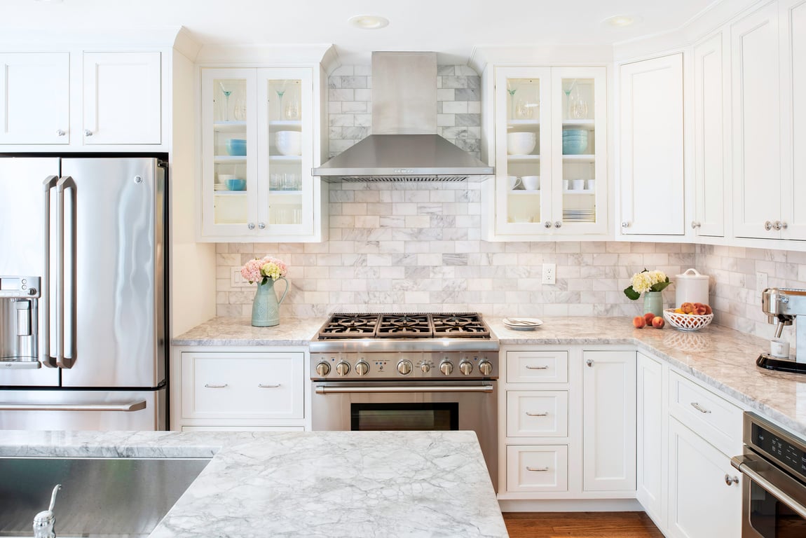 Bright modern kitchen with stainless appliances, marble countertops, and Bethesda Cabinets inset cabinetry