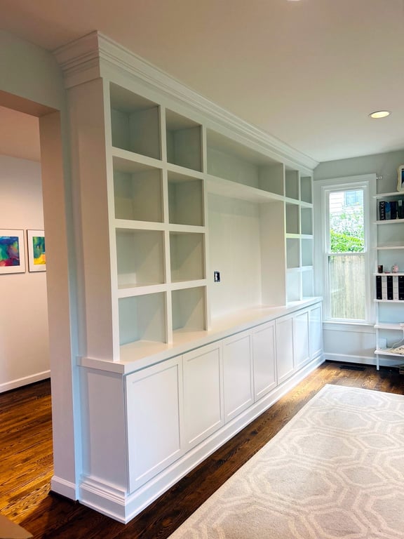 Angled view of a custom white built-in bookcase wall with lower cabinets