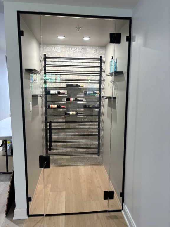 Glass-enclosed basement wine cellar with custom racking