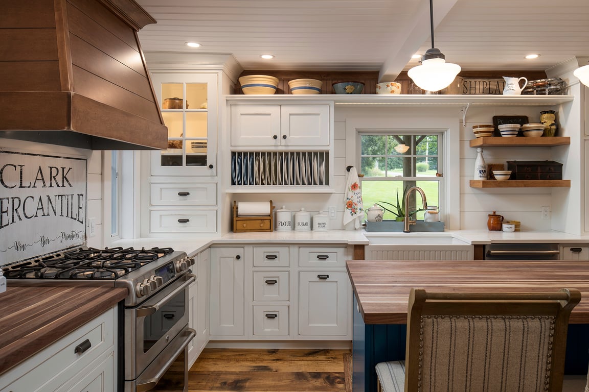A cozy farmhouse kitchen in Bethesda, Maryland, with white cabinets, open shelves, farmhouse sink, and rustic decor