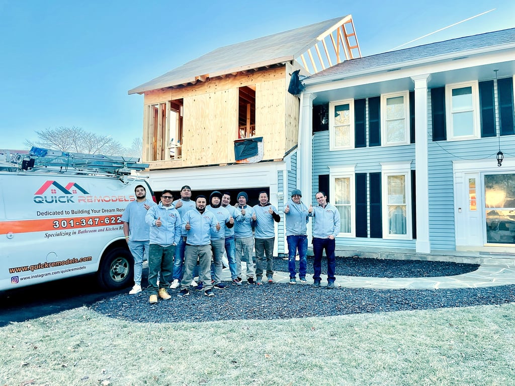 The QuickRemodels team in front of a completed home addition with the company van in the Bethesda area