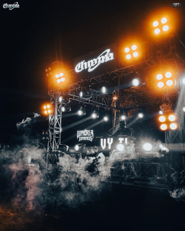 VYTL stage branding lit up behind the DJ booth at dusk