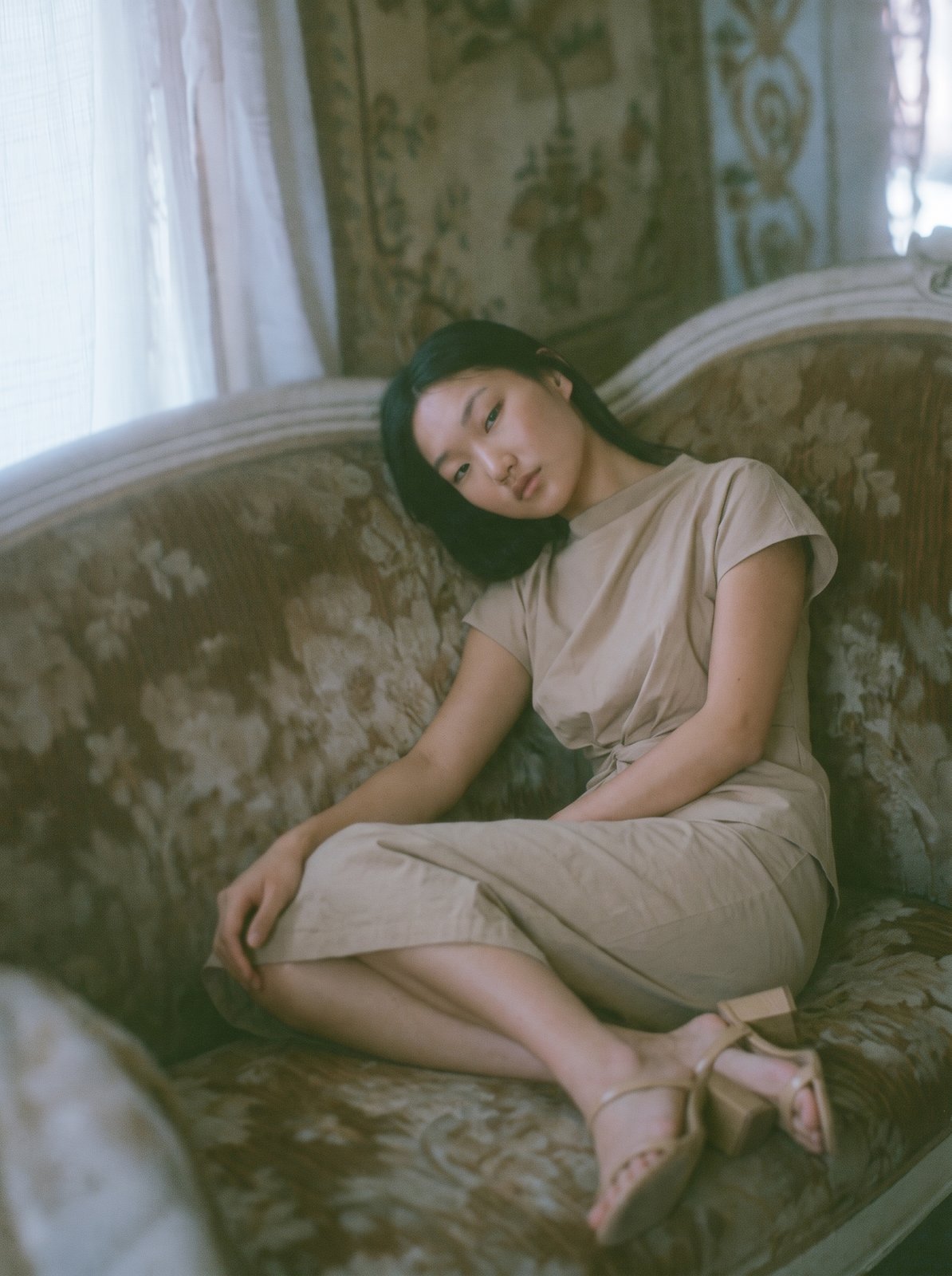 결과 — 베이지 드레스와 샌들 그대로, 소파에 기대앉은 자세와 필름 톤
