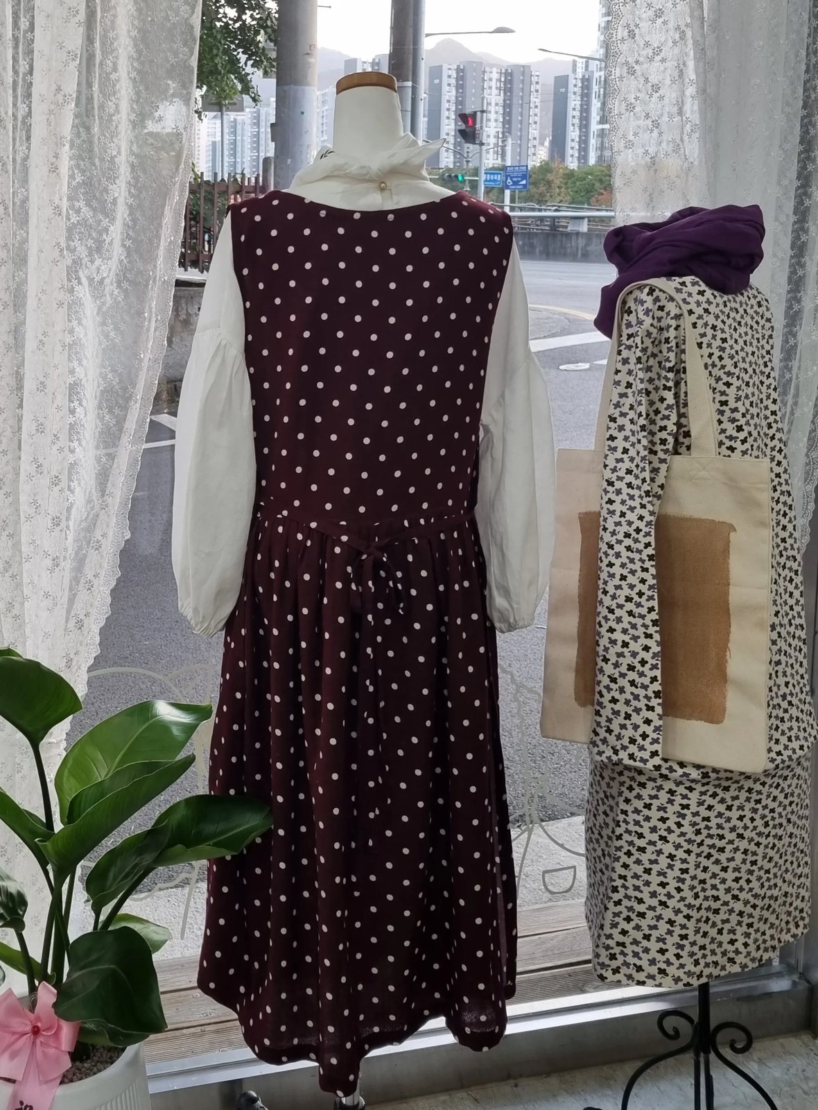 쇼윈도 마네킹에 입혀진 버건디 물방울 원피스