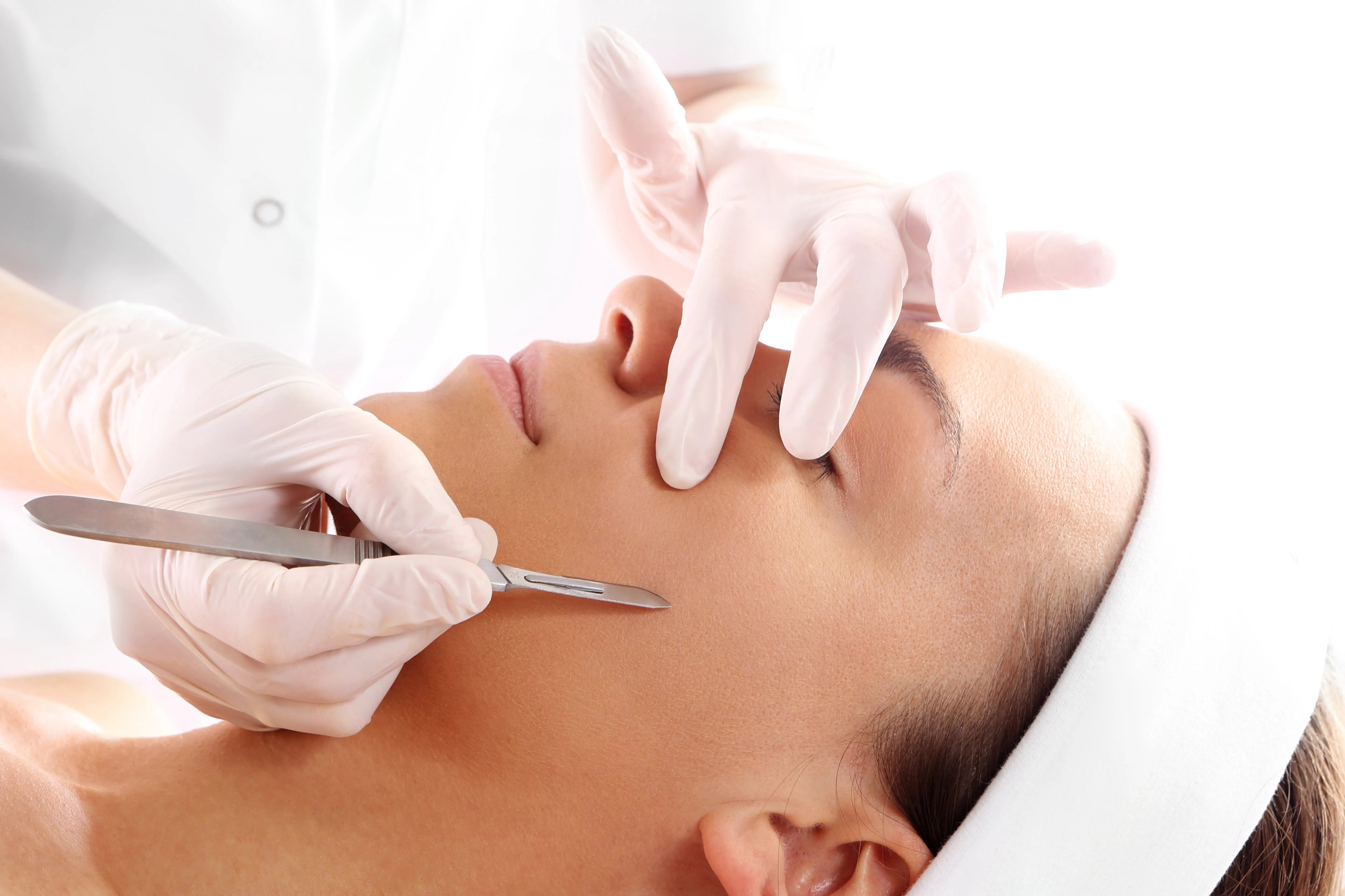 Woman receiving a professional dermaplaning facial treatment at a luxury med spa