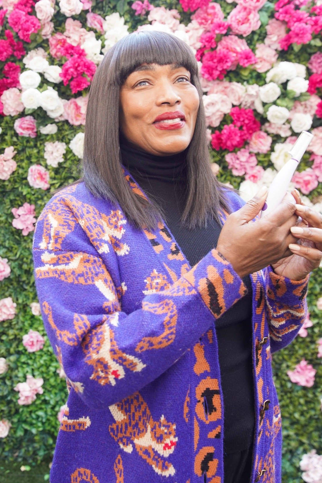Angela Bassett holding the SonicSmooth Pro+ device