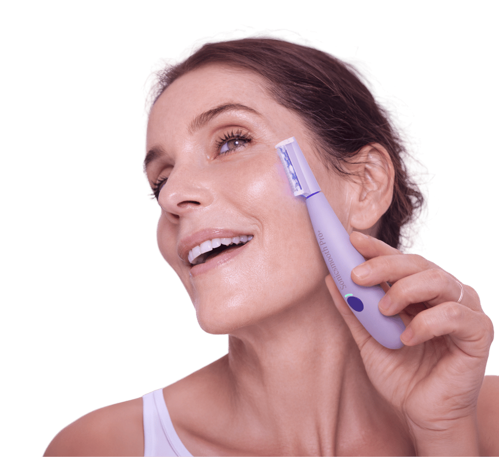 Woman using the SonicSmooth Pro+ device on her face