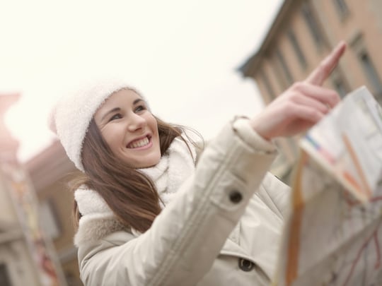 Person pointing forward in a white jacket and hat