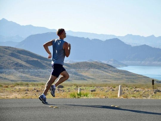 Person running on a scenic road