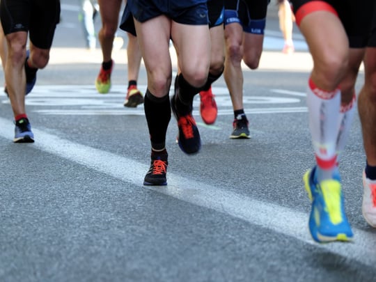 Persons running on an asphalt road