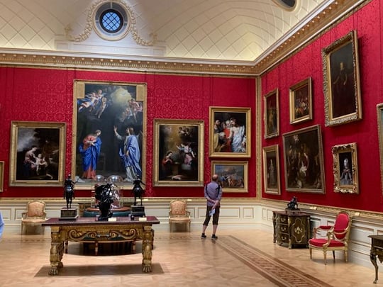Man looking at painting in an opulent room