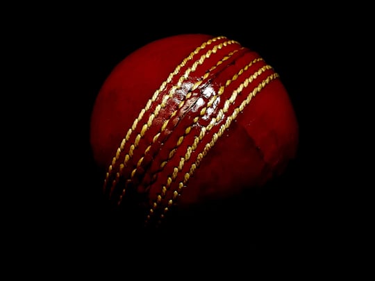 Red cricket ball on dark background