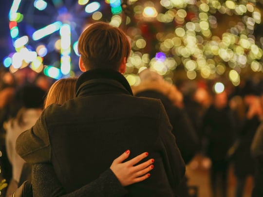 Couple looking out over Christmas outdoor gathering