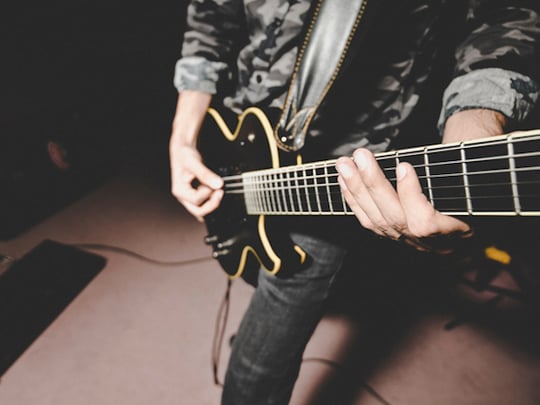 Black electric guitar being played