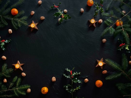Candles and Christmas decorations on slate background