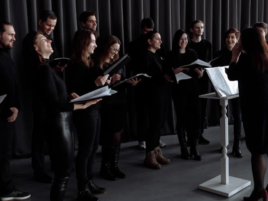 Group of people in black outfits about to sing