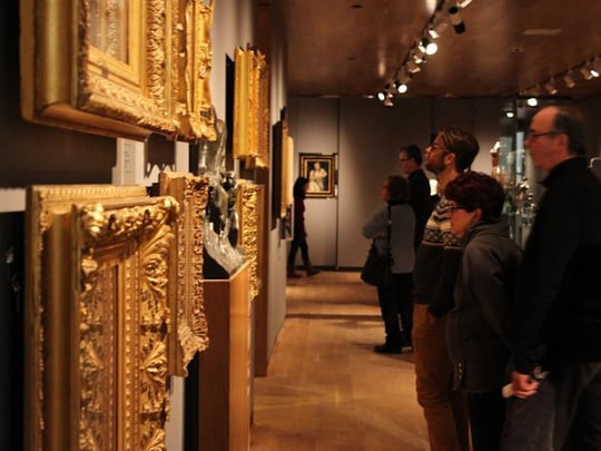 Patrons looking at art in gold frames