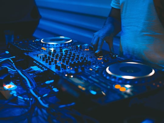 DJ and mixing decks in a blue light