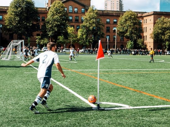 Man playing in a football match doing a corner kick