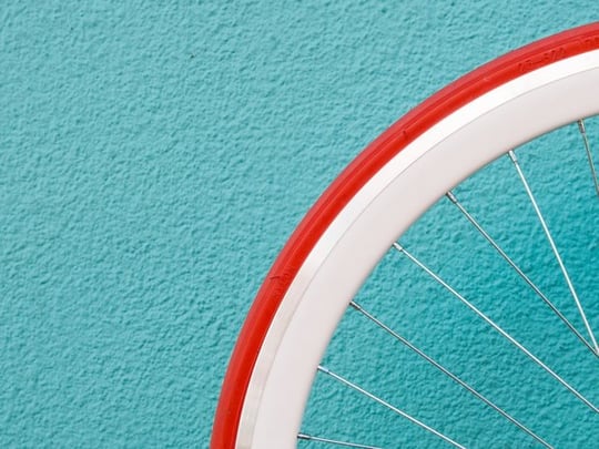 Bicycle wheel against a bright wall