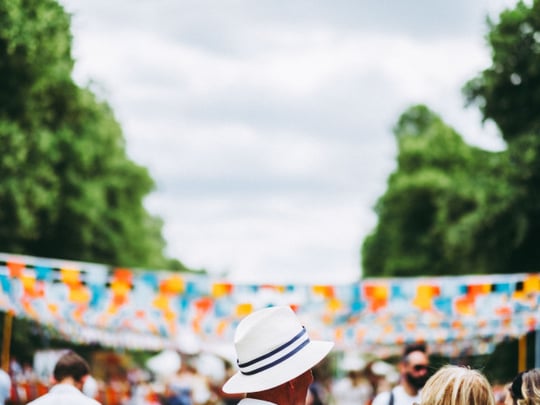 Person in white hat in front of blue and orange bunting