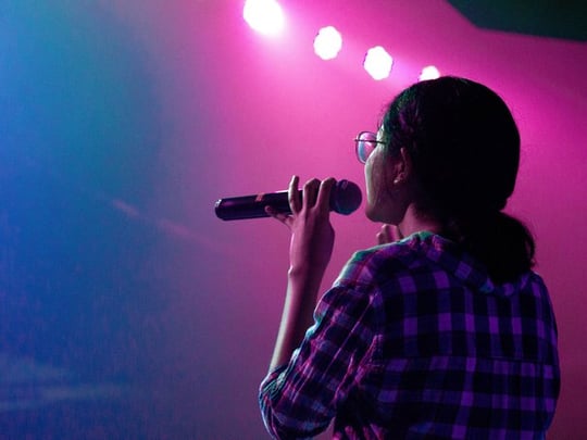 Woman onstage holding a microphone