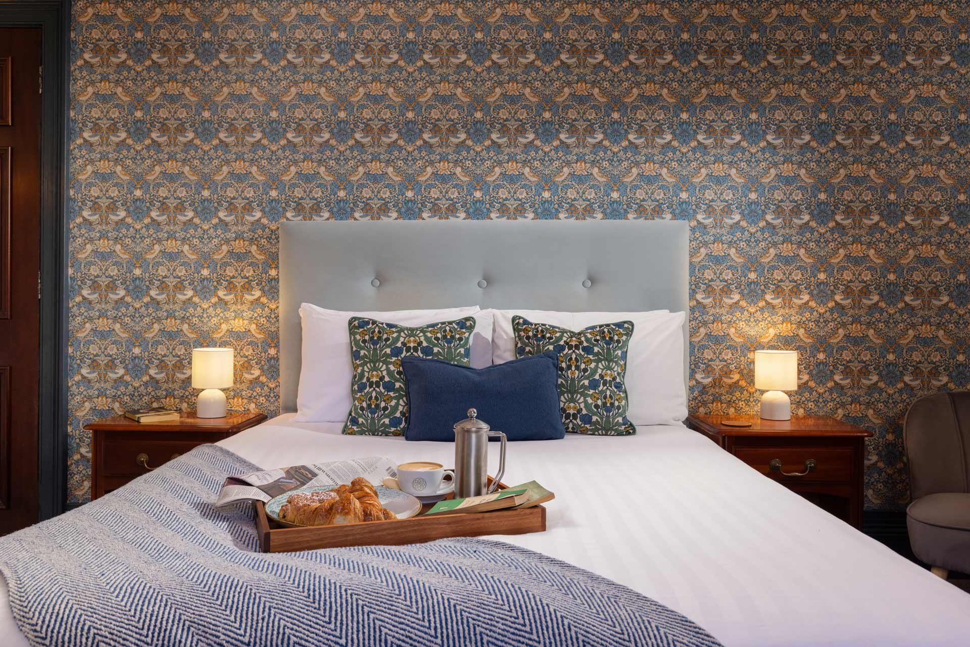 Cosy hotel bedroom with breakfast tray on the bed, ideal for a winter break.
