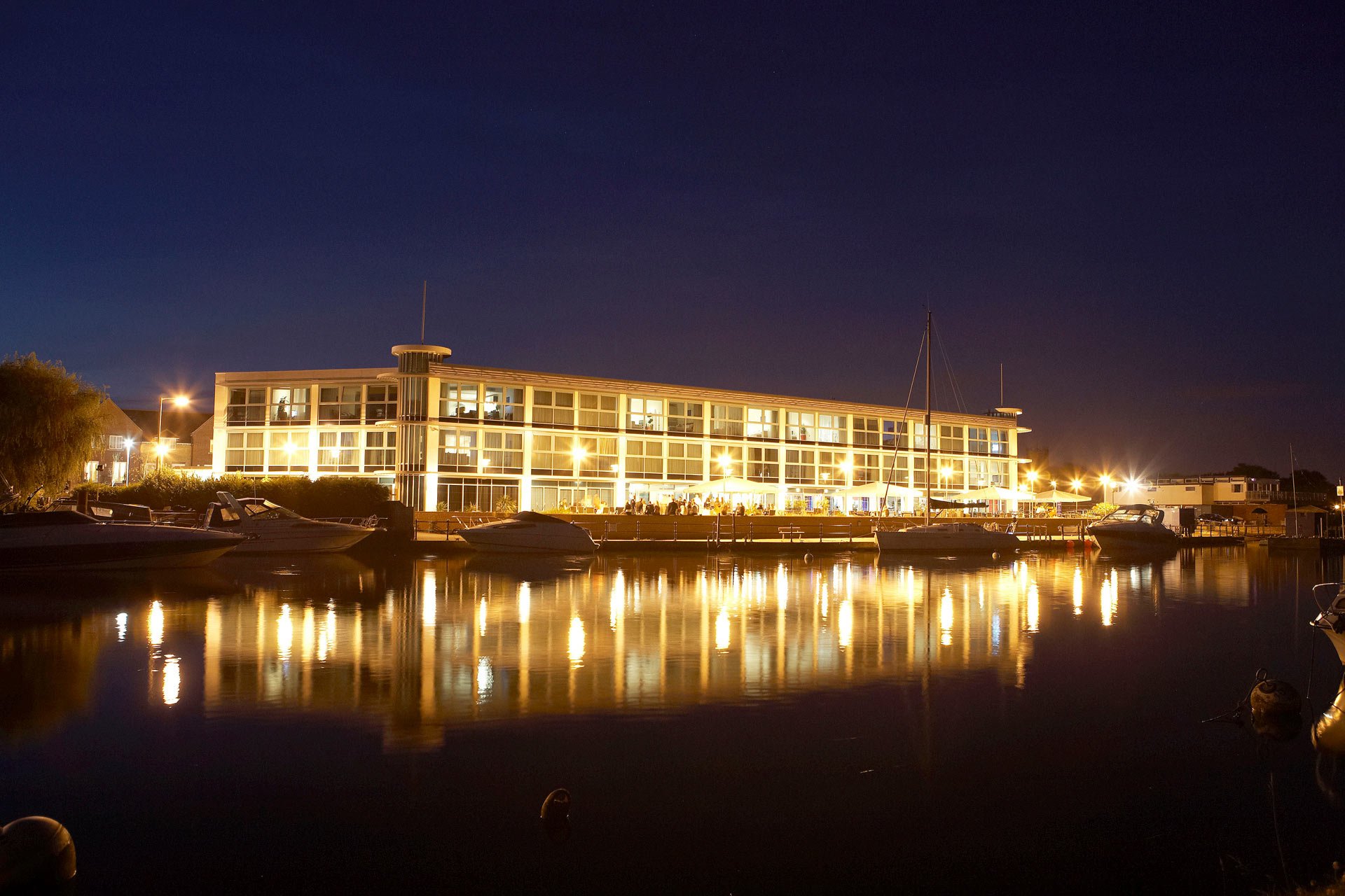 The Captains Club Hotel & Spa at night overlooking the harbour.