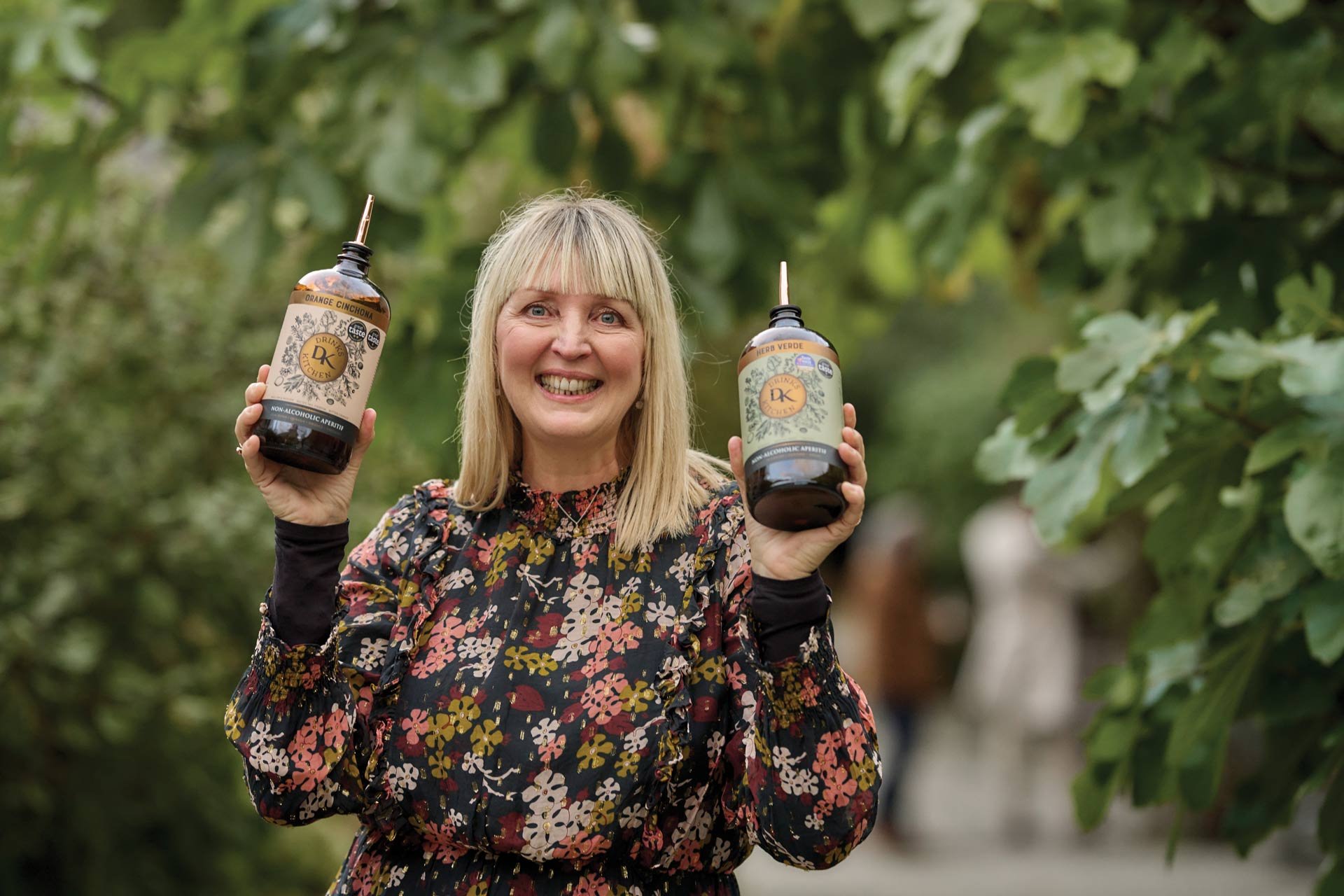 Blond woman holding the glorious 0% spirit that provides joy in a glass