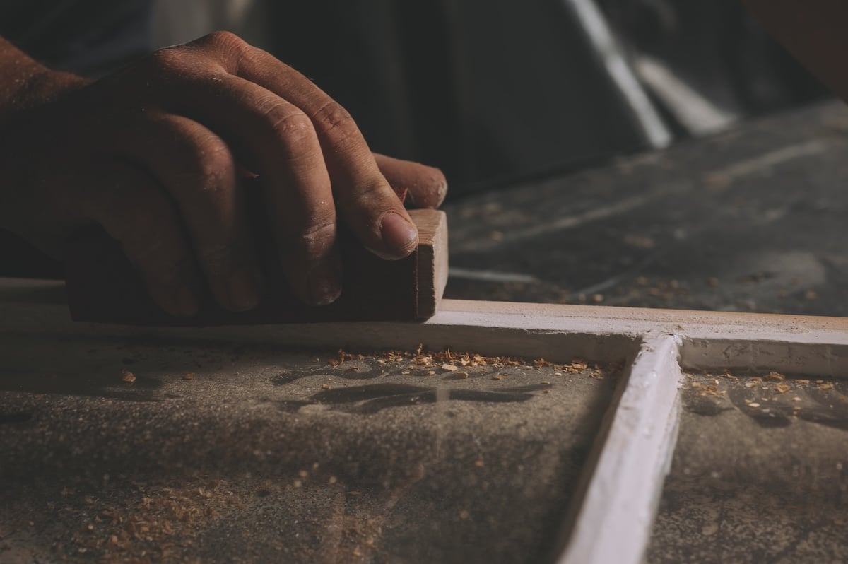 craftspeople filing a window frame