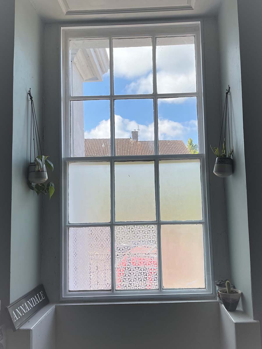 Interior view period home with sash windows fitted with secondary glazing showing original frame and panel