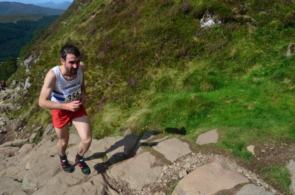 Finlay Wild races to the top of Ben Nevis. He is wearing red shorts and a white vest. Photo credit to John O'Neill