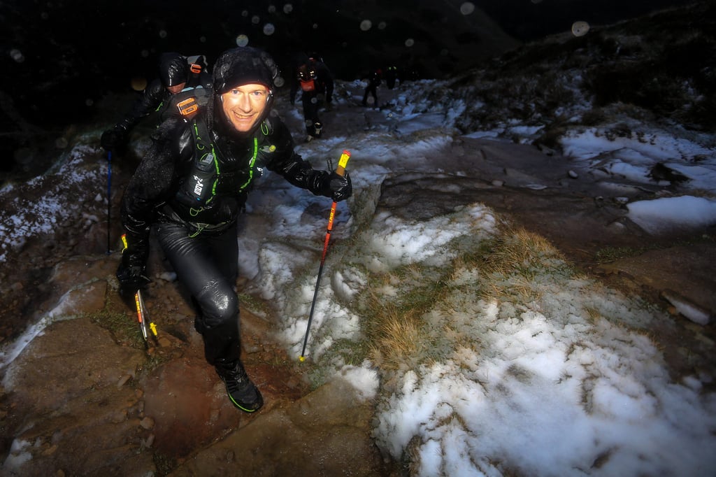 Runner Climbing Up A Hard Hill Ascent With Poles