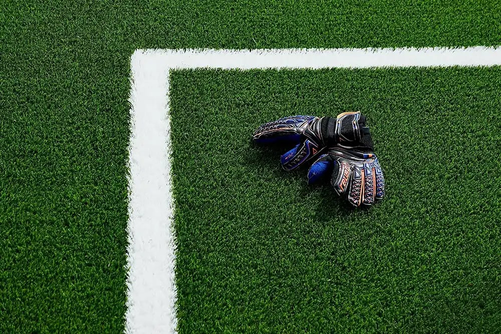 Overhead photo of goalkeeper gloves on a football pitch copy