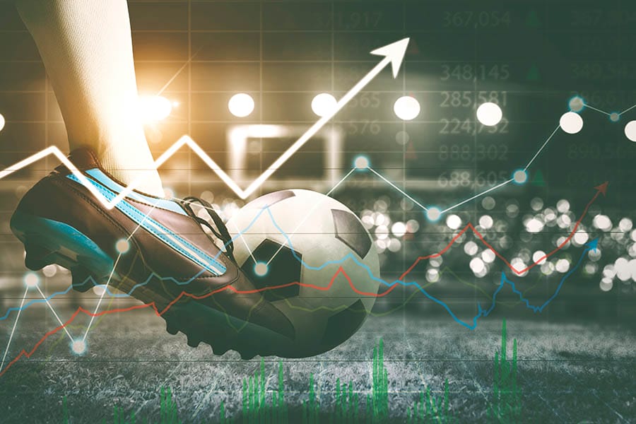 Double exposure of soccer player feet kicking a ball in the stadium with upward arrow background