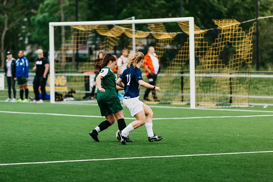 Two women playing soccer match