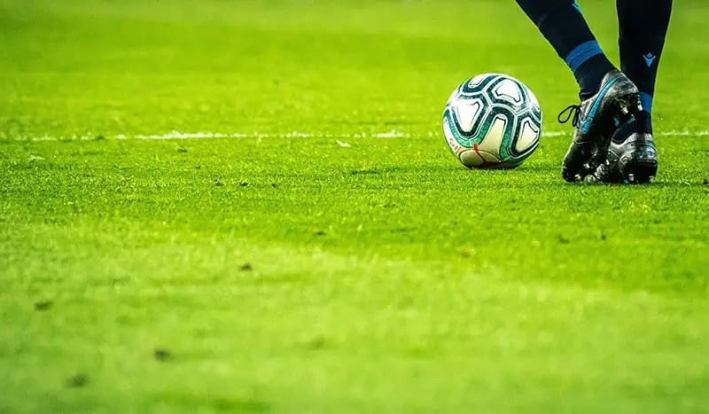 Footballer's Legs Kicking a Ball