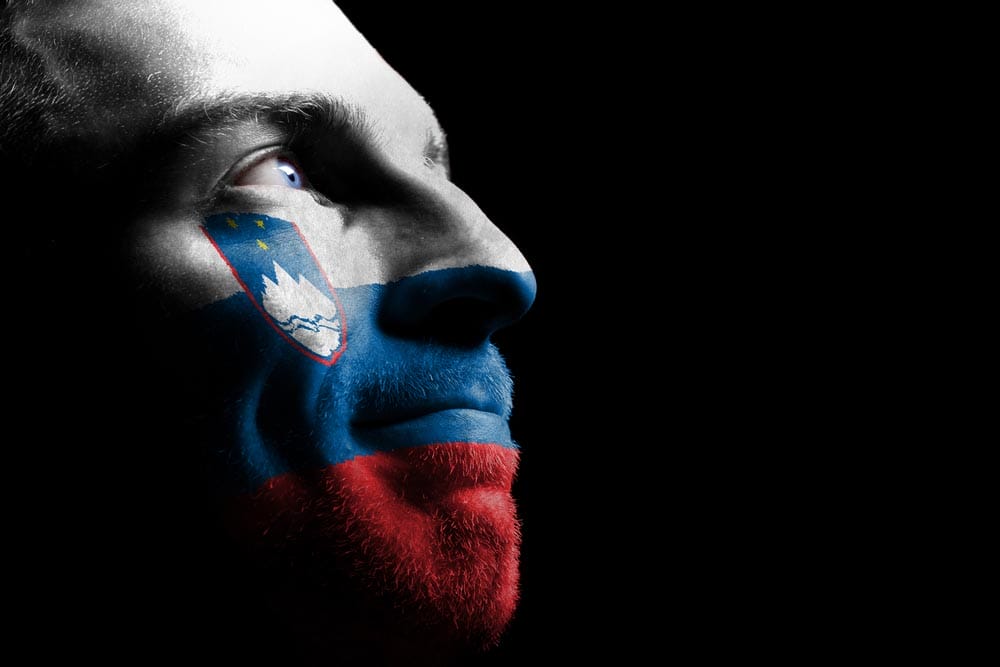 Sports fan - a patriot. On the painted colors of the flag of his country on his face.