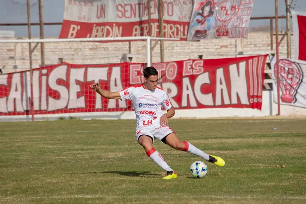 footballer kicking a ball in white kit