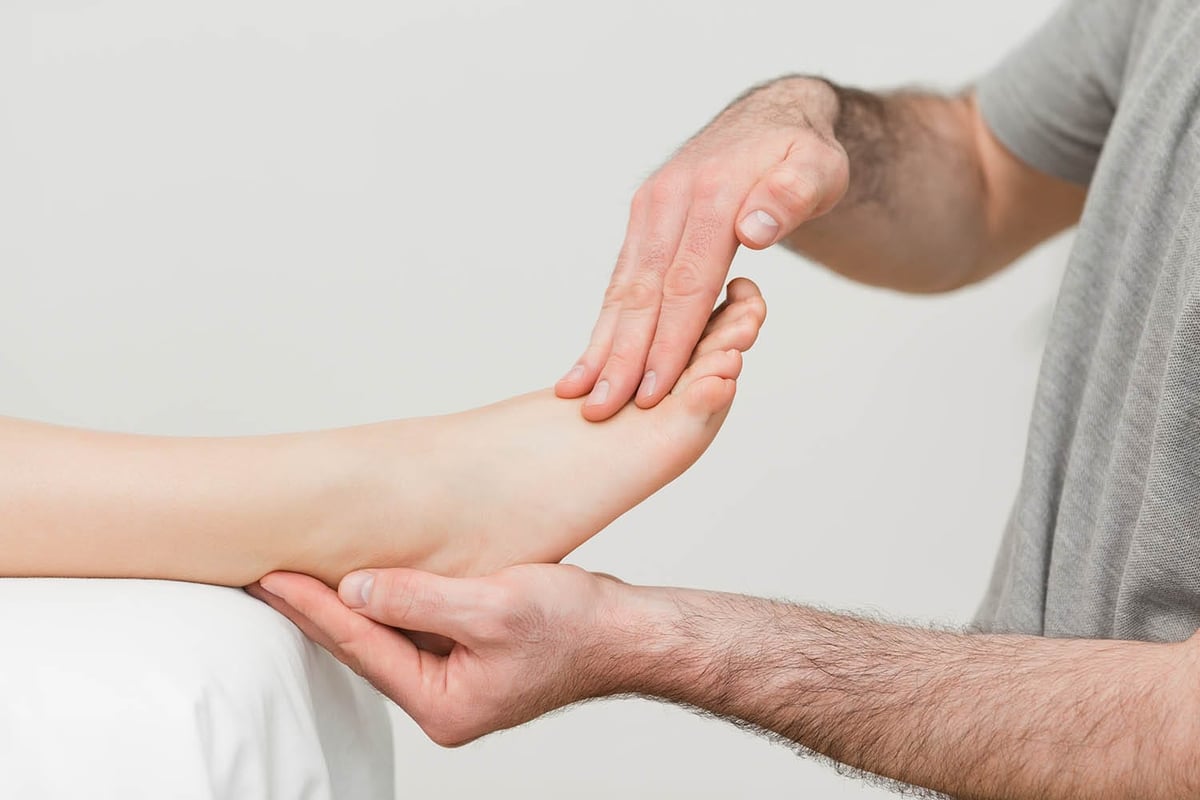 Doctor holding the foot of a patient in a room