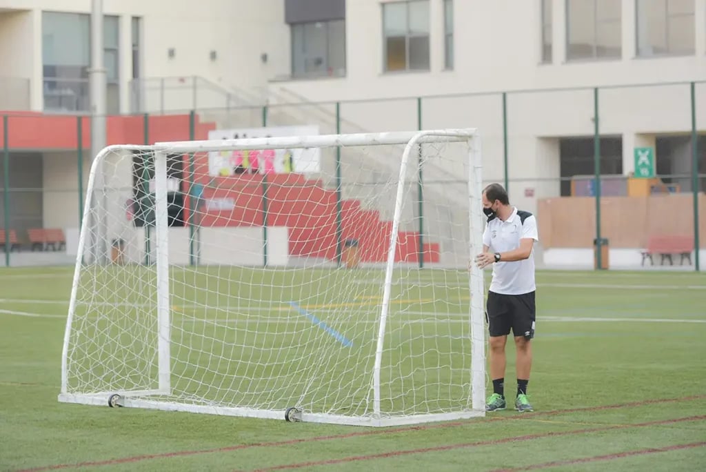 Soccer coach moving a football goal