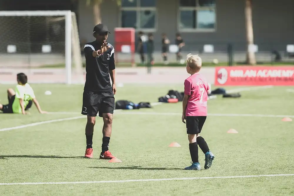 Man coaching a young football player