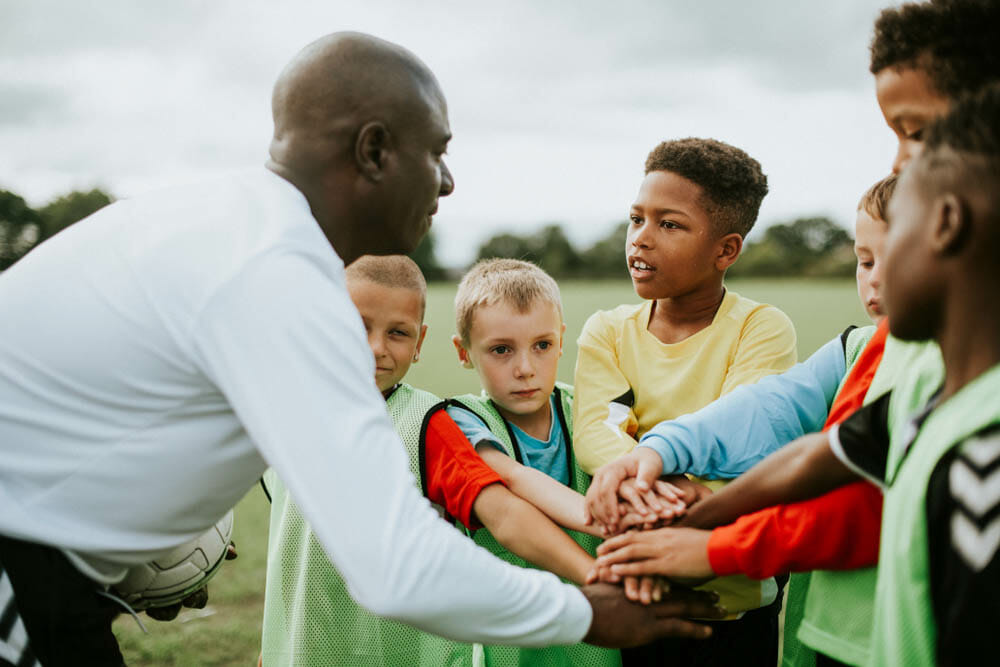 Junior football team stacking hands before a match