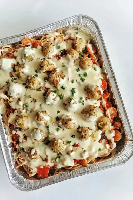 Looking down at a Pasta tray bake covered in cheese on a table