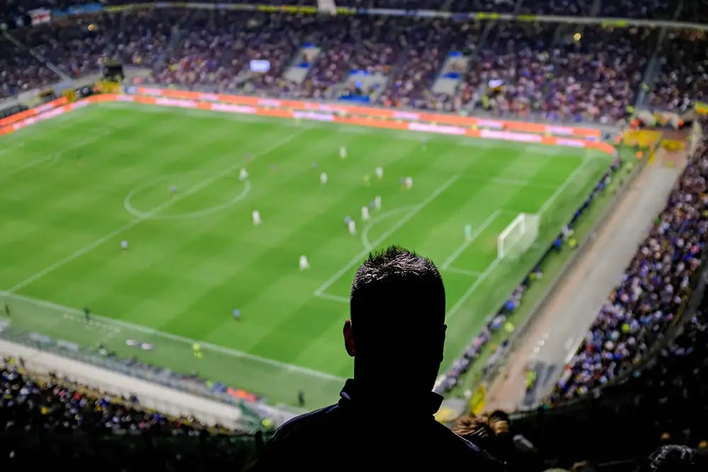 Silhouette of a man watching a football match