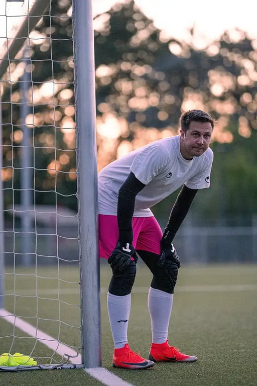 Goalkeeper in white top and pink shorts